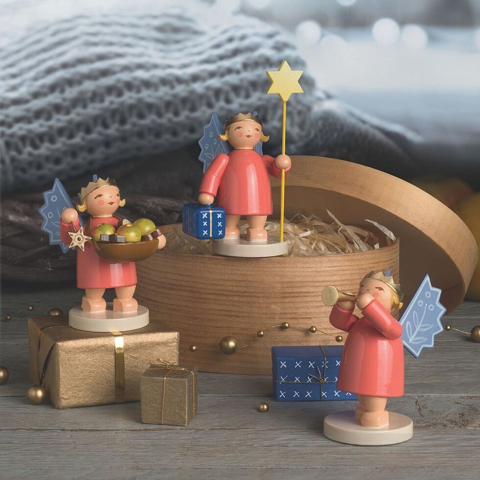 Handgefertigte Kronenengel von Wendt & Kühn mit Stern, Geschenken und Flöte in einer weihnachtlichen Dekoration.