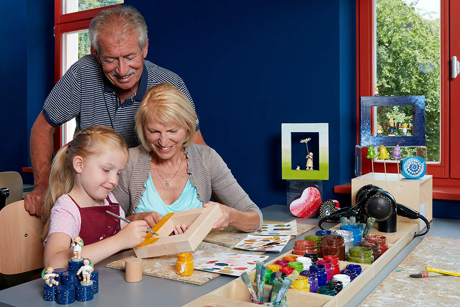 Großeltern basteln in der Kreativ-Galerie mit ihrer Enkeltochter. 